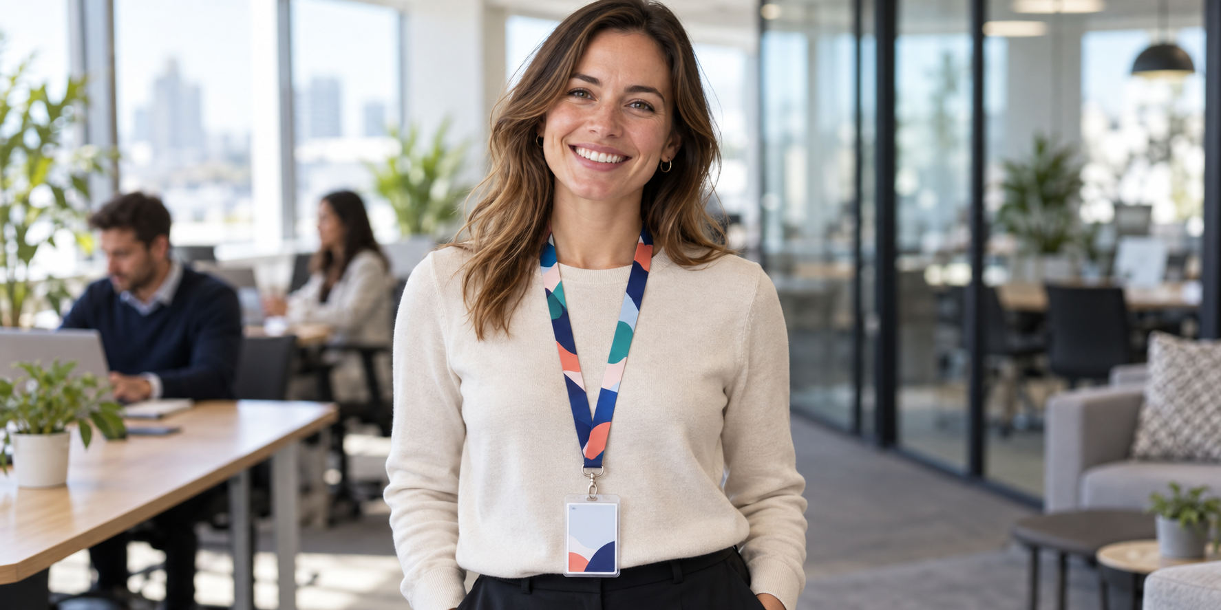 An office worker wearing a branded lanyard with an access card, smiling professionally.